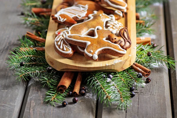 Пряничное печенье на деревянном подносе среди ели — стоковое фото