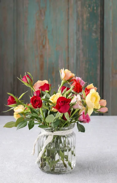 Buquê de rosas coloridas em vaso de vidro . — Fotografia de Stock