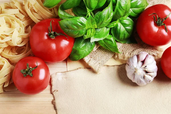 Tomaten, Knoblauch und Basilikum auf Jutesack-Hintergrund. — Stockfoto