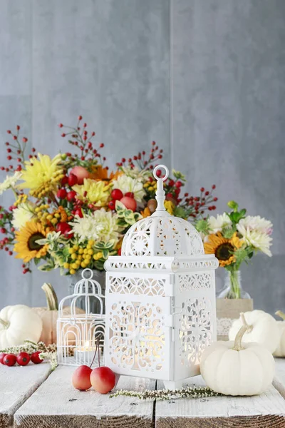 Hermosa linterna blanca, flores y calabazas sobre la mesa —  Fotos de Stock
