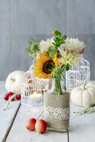 Table decoration with sunflowers and dahlias. Candles inside vin