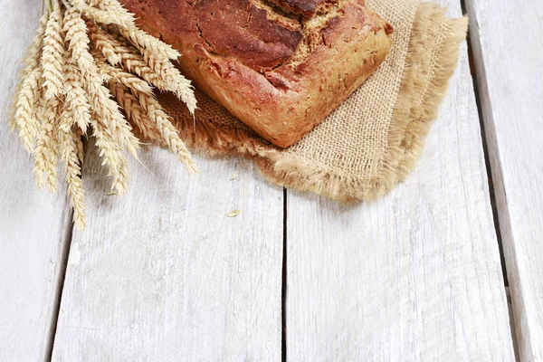 Bochenek chleba na drewnianym stole. — Zdjęcie stockowe