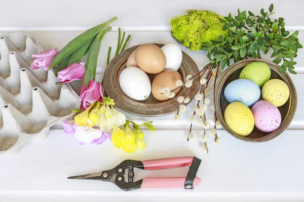 Frau zeigt, wie man Osterflorale Dekoration mit bunten E herstellt — Stockfoto