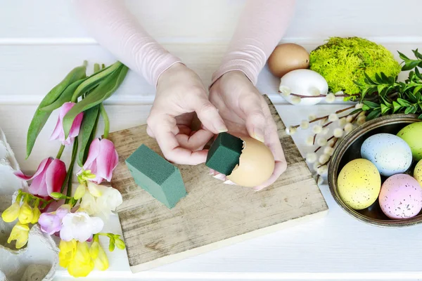 Woman shows how to make Easter floral decoration with colorful e — Stock Photo, Image