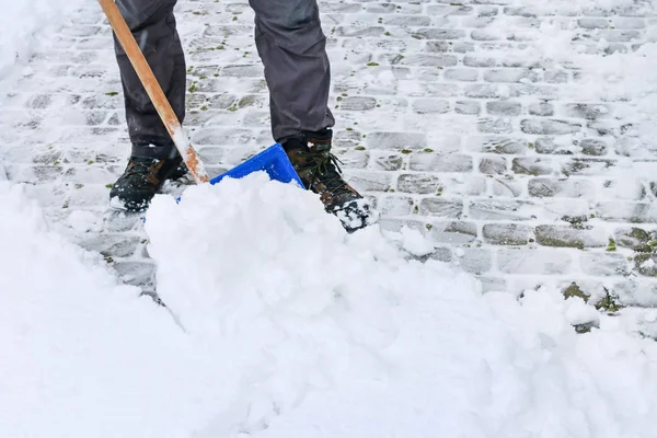 Man att ta bort snö från trottoaren efter snöstorm. — Stockfoto