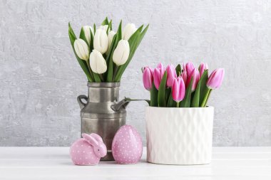 Pembe ve beyaz laleler, noktalı seramik tavşan ve büyük Paskalya yumurtası 