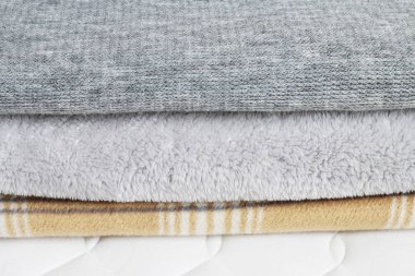 Üç battaniye: gri ve bej şilte üzerinde. 