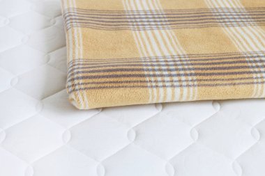 Yeni şilte üzerinde Bej battaniye. 