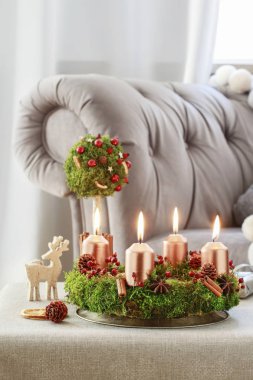 Yosun, tarçın çubukları ve rosa canina dalyapılmış Advent çelenk