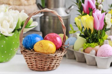 Masada Paskalya yumurtaları olan hasır sepet. Çiçek süslemeleri 