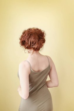 Sarı arka planda güzel genç kadının vücudu