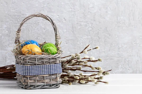 Korb mit Ostereiern und Kätzchen auf dem Tisch. — Stockfoto