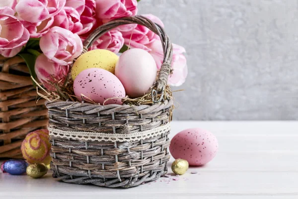 Bukett rosa tulpaner och korg med påskägg — Stockfoto