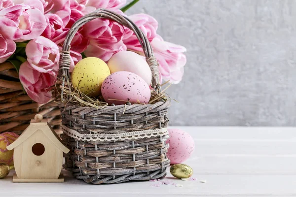 Bouquet de tulipes roses et panier d'œufs de Pâques — Photo