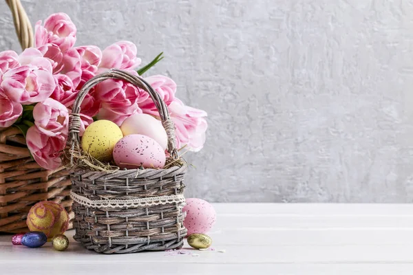 Bouquet de tulipes roses et panier d'œufs de Pâques — Photo