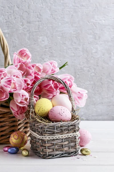 Bouquet de tulipes roses et panier d'œufs de Pâques — Photo