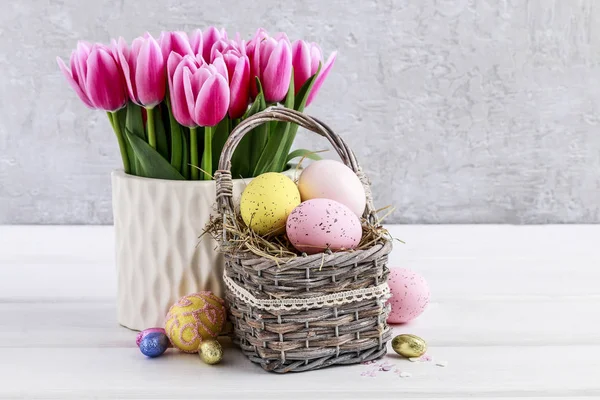 Bouquet de tulipes roses et panier d'œufs de Pâques — Photo