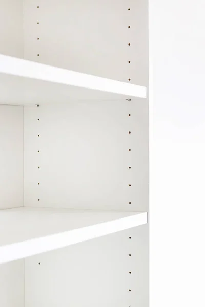Empty shelf in white cupboard.