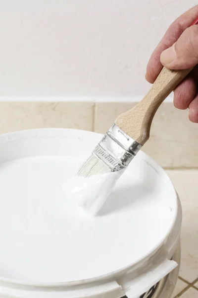 Cepillo y cubo de plástico con pintura blanca . — Foto de Stock