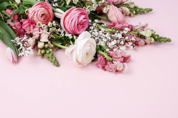 Bouquet of spring flowers on pink background.