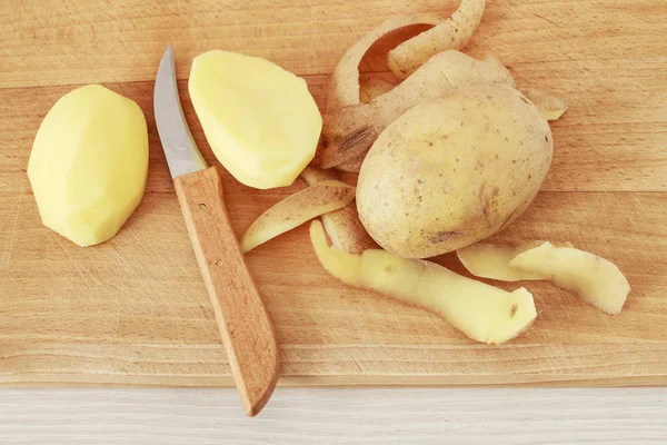 Descascando batatas em uma cozinha doméstica . — Fotografia de Stock