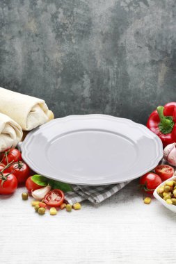 Boş tabak ve çeşitli sebzeler etrafında