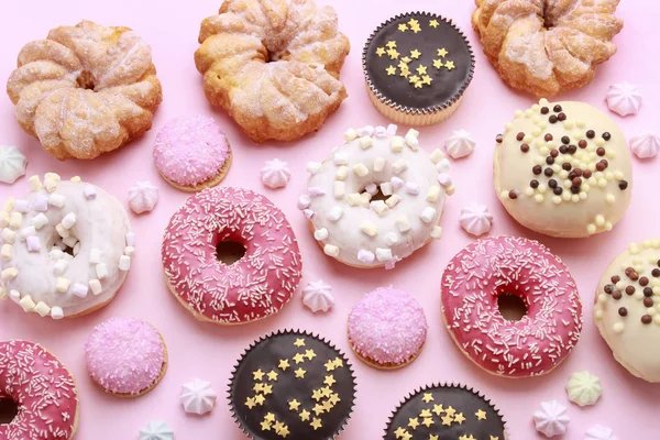 Verschillende soorten donuts op roze achtergrond. — Stockfoto