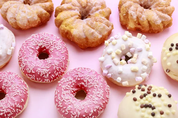 Vários tipos de rosquinhas no fundo rosa . — Fotografia de Stock