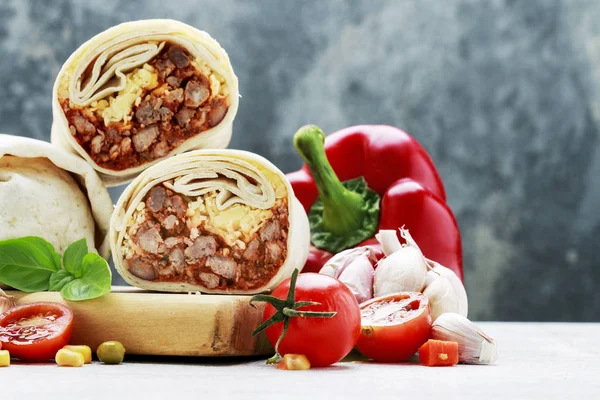 Un burrito - plato mexicano que consiste en una tortilla de harina con —  Fotos de Stock