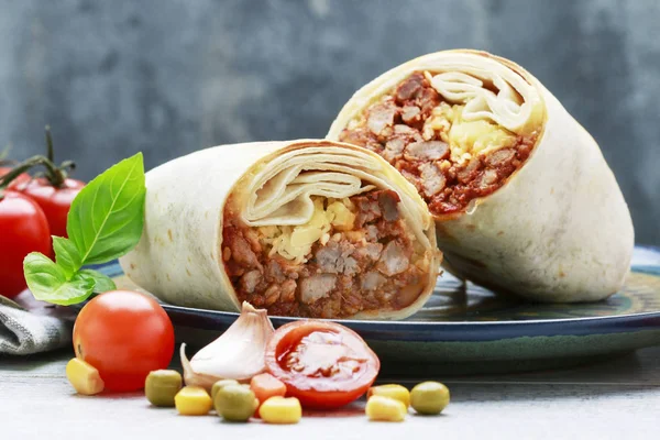 Un burrito - plato mexicano que consiste en una tortilla de harina con —  Fotos de Stock