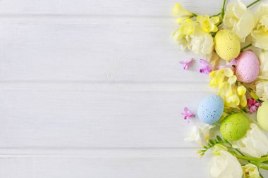 Beyaz ahşap masa üzerinde lale ler ve freesias. Flo arasında Paskalya yumurtaları
