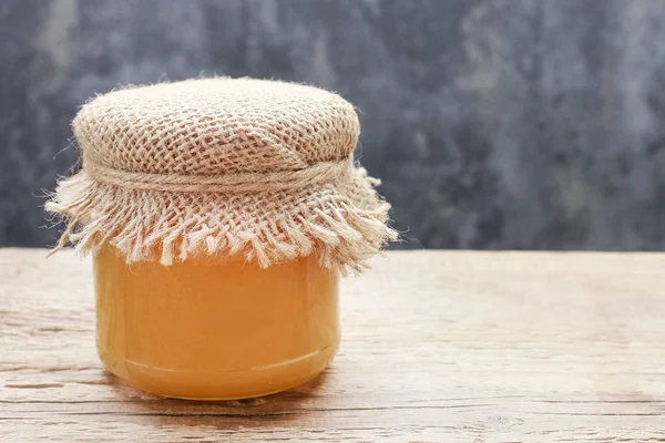 Honey in glass jar on wooden background. — Stock Photo, Image