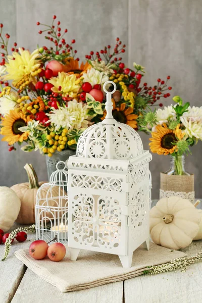 Piękna biała latarnia, kwiaty i dynie na stole — Zdjęcie stockowe