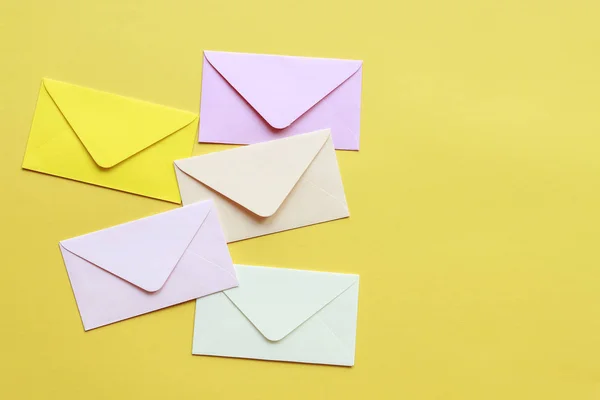 Envelopes coloridos sobre fundo amarelo — Fotografia de Stock