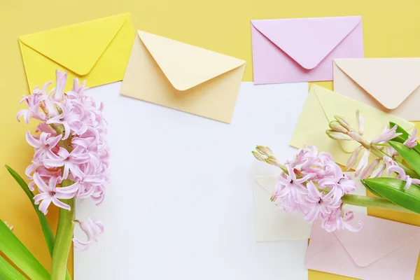 Färgglada kuvert och hyacint blommor på gul bakgrund — Stockfoto