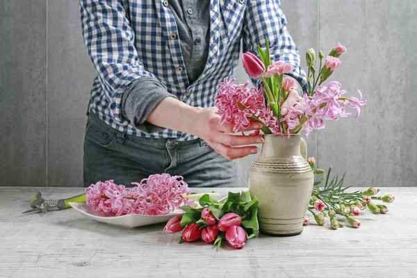 Mujer muestra cómo hacer ramo de primavera con tulipán, jacinto y — Foto de Stock