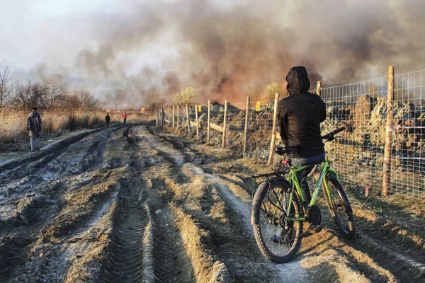 KRAKOW, POLONIA - 28 de marzo de 2012: El ciclista está viendo un gran incendio — Foto de Stock