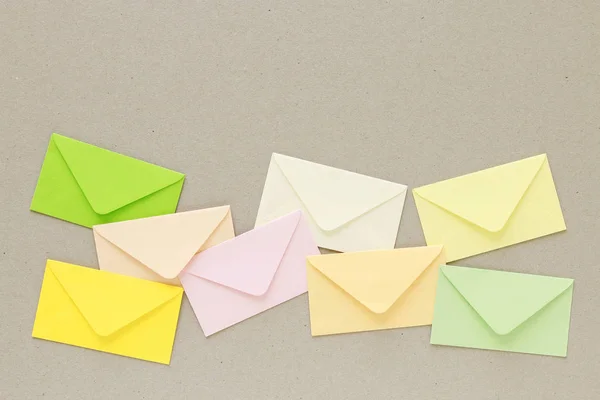 Envelopes coloridos sobre fundo de papel cinza, espaço de cópia . — Fotografia de Stock