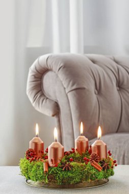 Yosun, tarçın çubukları ve rosa canina dalyapılmış Advent çelenk