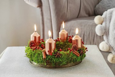 Yosun, tarçın çubukları ve rosa canina dalyapılmış Advent çelenk