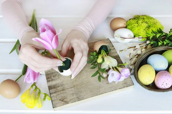 Frau zeigt, wie man Osterflorale Dekoration mit bunten E herstellt — Stockfoto