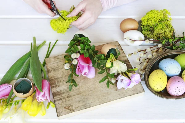 Woman shows how to make Easter floral decoration with colorful e — Stock Photo, Image