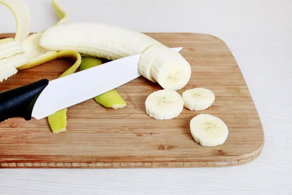 Нарезанный банан на деревянной доске. — стоковое фото