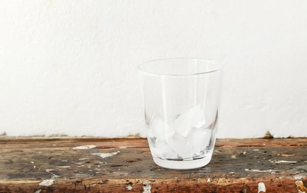 Eiswürfel im Glas stehen auf einem schmutzigen Tisch — Stockfoto