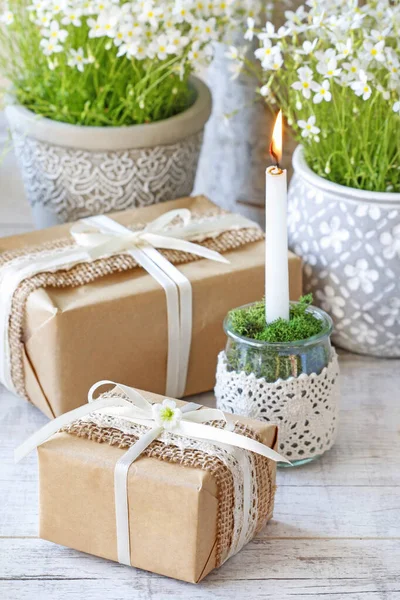 Wunderschön verpackte Geschenke und Blumen im Hintergrund — Stockfoto