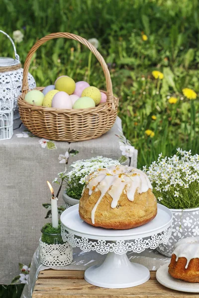 Traditional Easter cake and basket with colorful eggs in the gar — Stock Photo, Image