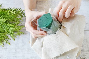 Kadın, kırmızı güllerle nasıl çiçek aranjmanı yapılacağını gösteriyor. 