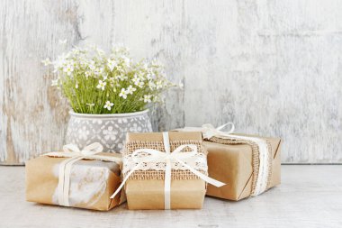 Güzel paketlenmiş hediyeler ve beyaz çiçekler.