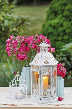 Çiçek masa düzenleme pembe güller ve romantik fenerler. 