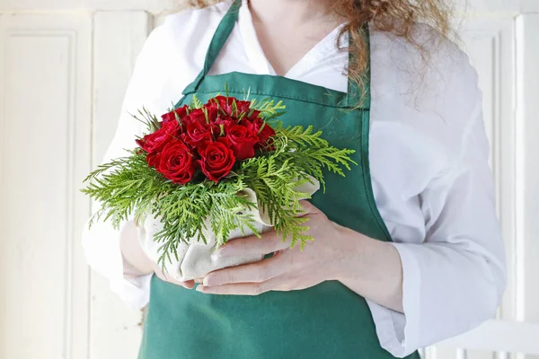 Mujer muestra cómo hacer un arreglo floral con rosas rojas y —  Fotos de Stock